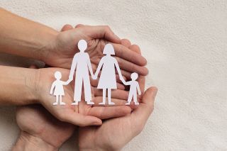 © Song_about_summer - stock.adobe.com Foto: Hände mit Papierausschnitt einer Familie