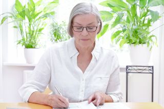 © agenturfotografin - stock.adobe.com Foto: Ältere Dame bearbeitet Unterlagen